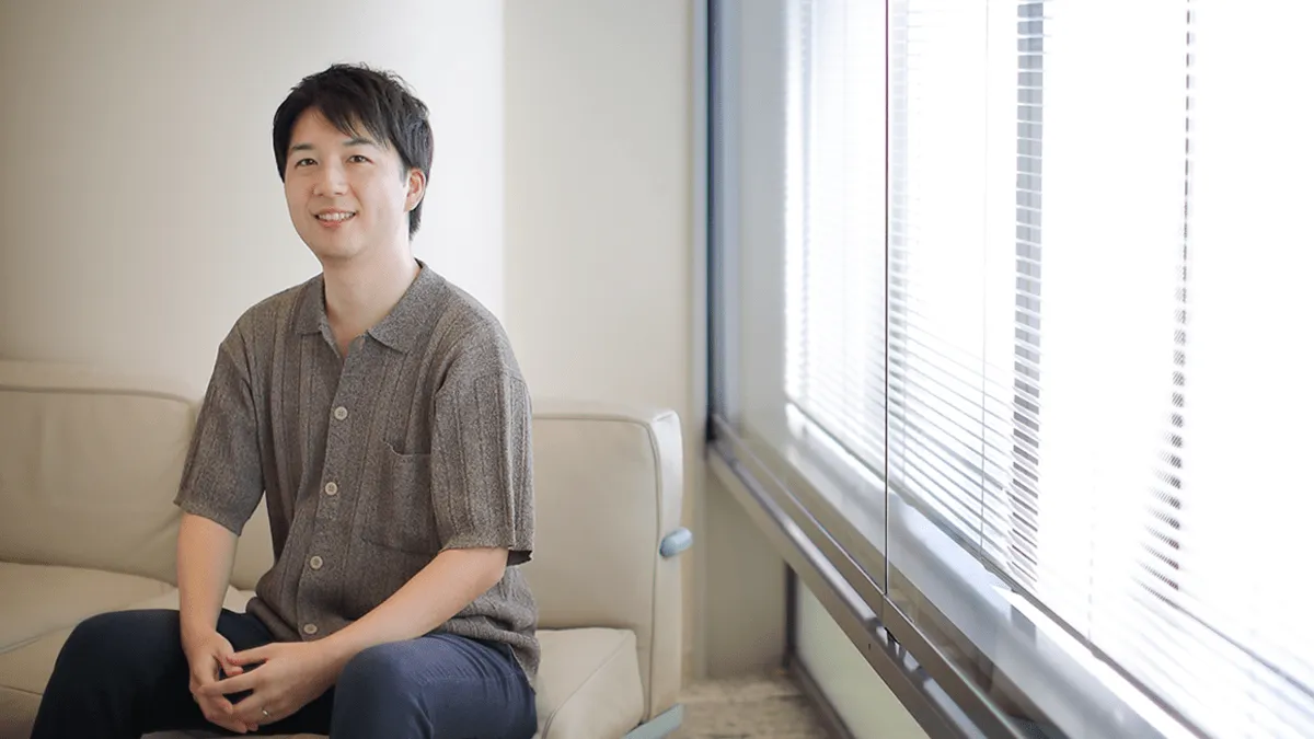 社員の男性が椅子に座っている画像