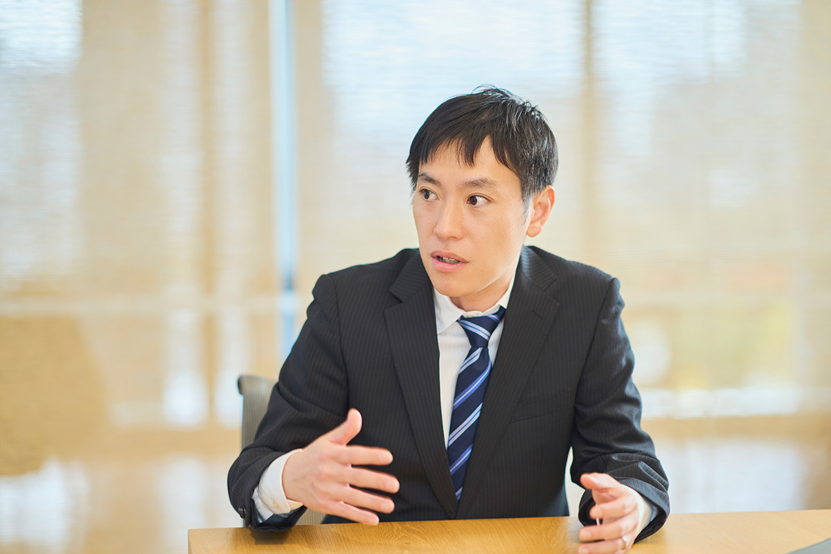 写真：日本拠点とグローバル網を結ぶ三社協業の強みを語る岡田 祐輔