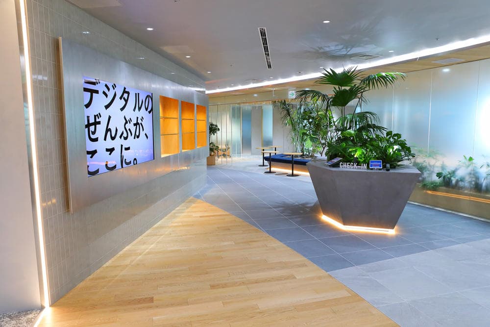 うップンすっきりペーパーの展示の様子を写したもの。高さ2メートルほどのブースの白を基調とした壁一面に、5列かける4段、合計20個のトイレットペーパーホルダーが取り付けられている。ホルダーにはそれぞれうップンすっきりペーパーがセットされている。