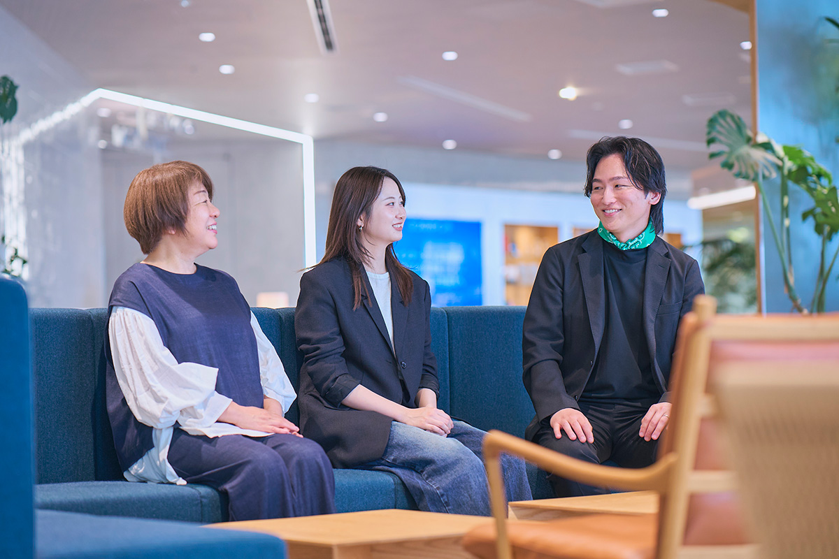 写真：電通デジタルのオフィスで竹内、吉海、土橋の3人が椅子に座り会話している